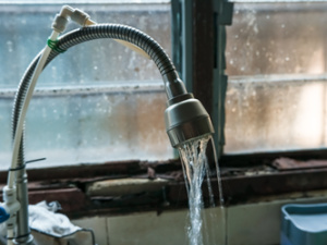 Water is flowing out of the faucet at a low pressure.