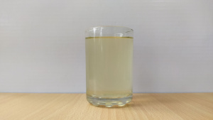 On a white background, there is a table holding a glass of water filled with tannins.