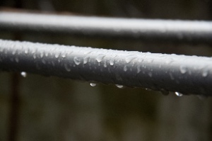 Water droplets form on a steel pipe, demonstrating the phenomenon of cold water pipe condensation.